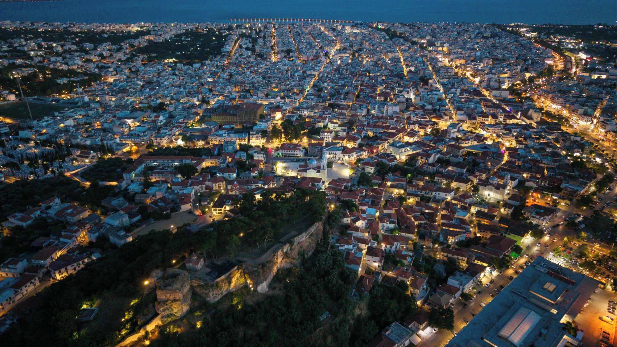 Vista aérea de una zona urbana densamente poblada, con una iglesia destacada y una carretera costera.