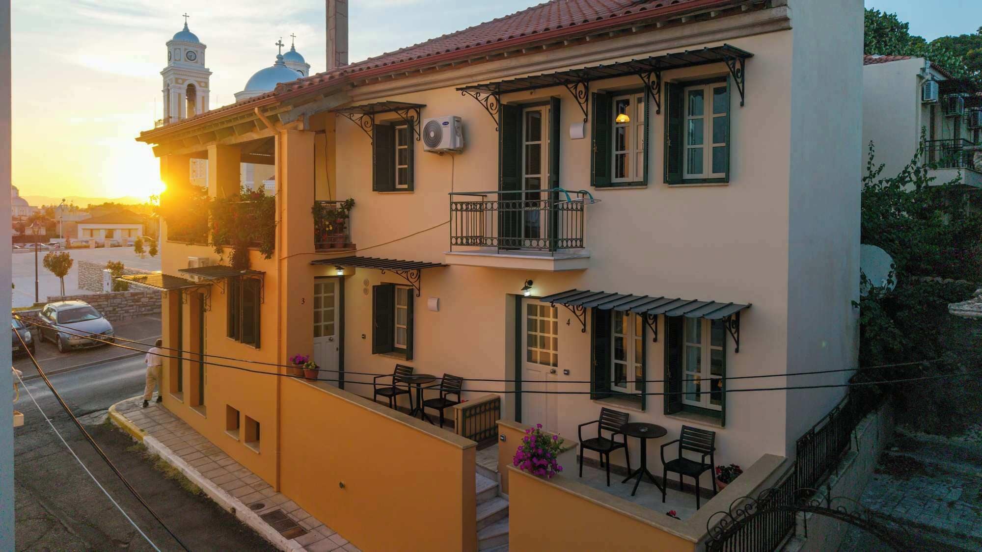 A two-story building with balconies, outdoor seating, and a street view.