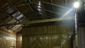 A room with a bed, wooden walls, and a ceiling with a bamboo design. - N D Farms (Kanakapura)