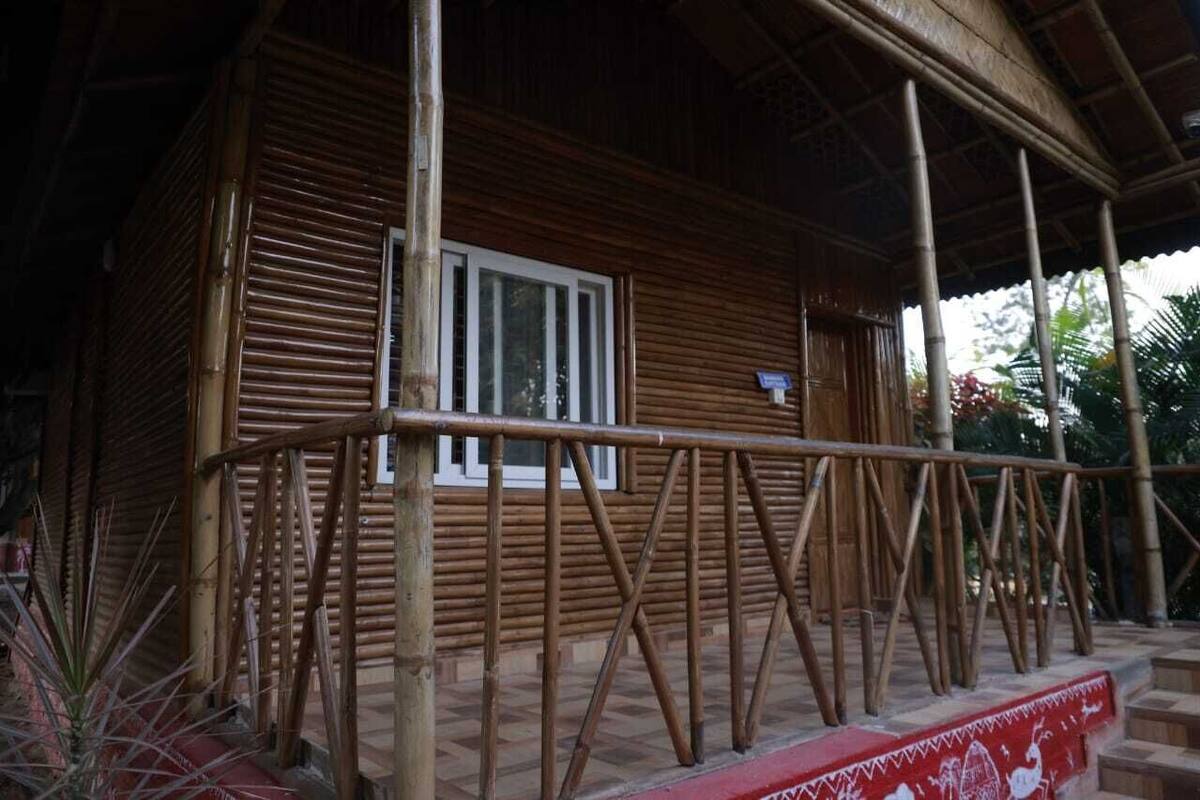 A wooden building with a window and a covered porch.