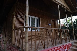 A wooden building with a window and a covered porch.