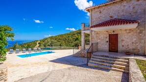 A stone building with a pool, outdoor seating, and a view of the sea. - Sunset Vista Villas Deluxe III (Zakynthos)