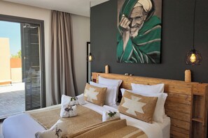 A hotel room with a bed, a wooden headboard, a large painting, and a view through a sliding door. - Villa Loulou, heated pool and breakfast included (Marrakech)
