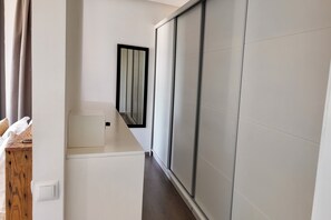 A hallway with a sliding door, a mirror, and a small white cabinet. - Villa Loulou, heated pool and breakfast included (Marrakech)