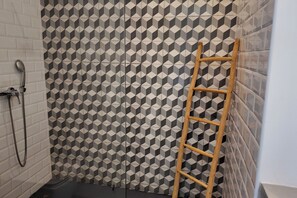 A shower area with a geometric patterned tile wall, a wooden ladder, and a showerhead. - Villa Loulou, heated pool and breakfast included (Marrakech)