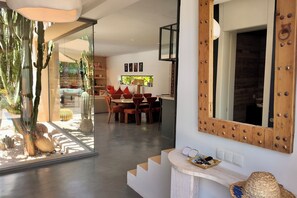 A modern interior with a dining area, a staircase, and a large mirror. - Villa Loulou, heated pool and breakfast included (Marrakech)