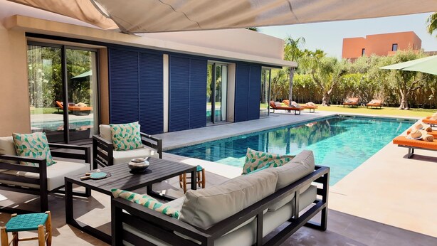 An outdoor pool area with lounge chairs, a table, and a covered seating area. - Villa Loulou, heated pool and breakfast included (Marrakech)