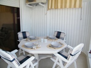 A round dining table with four chairs, each with a striped cushion. - Apartment sea view, AC and parking - 6 guests (Gandia)