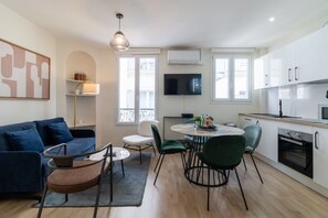 Ein modernes Apartment mit Wohnzimmer, Essbereich und Küche.