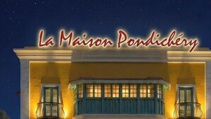 Un edificio de dos plantas con balcones y un letrero que dice 'La Maison Pondichéry'.