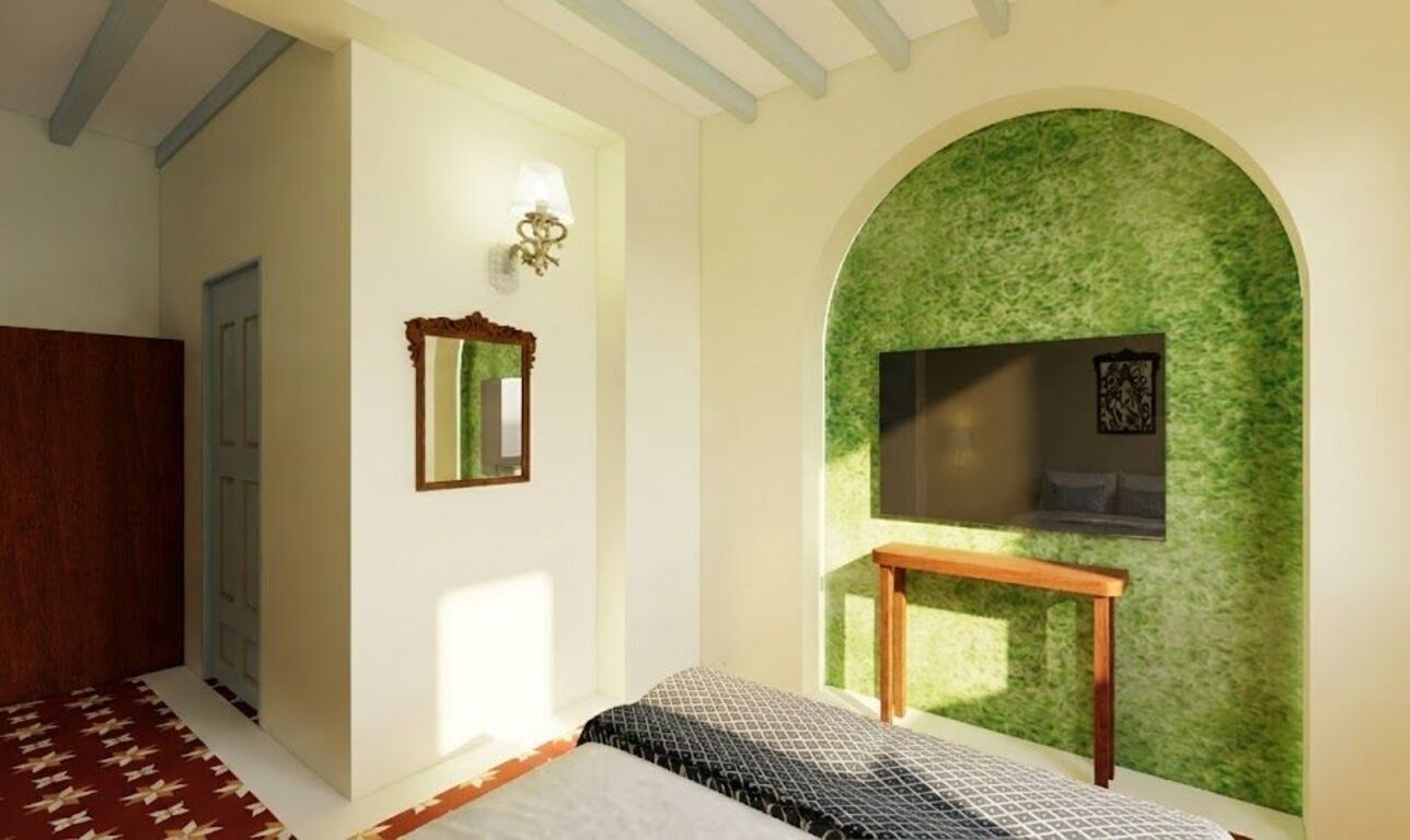 A bedroom with a bed, a mirror, a wall-mounted TV, and a green textured wall.