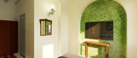 Un dormitorio con cama, espejo, televisor montado en la pared y una pared verde con textura.