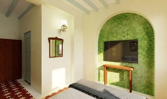 Un dormitorio con cama, espejo, televisor montado en la pared y una pared verde con textura.