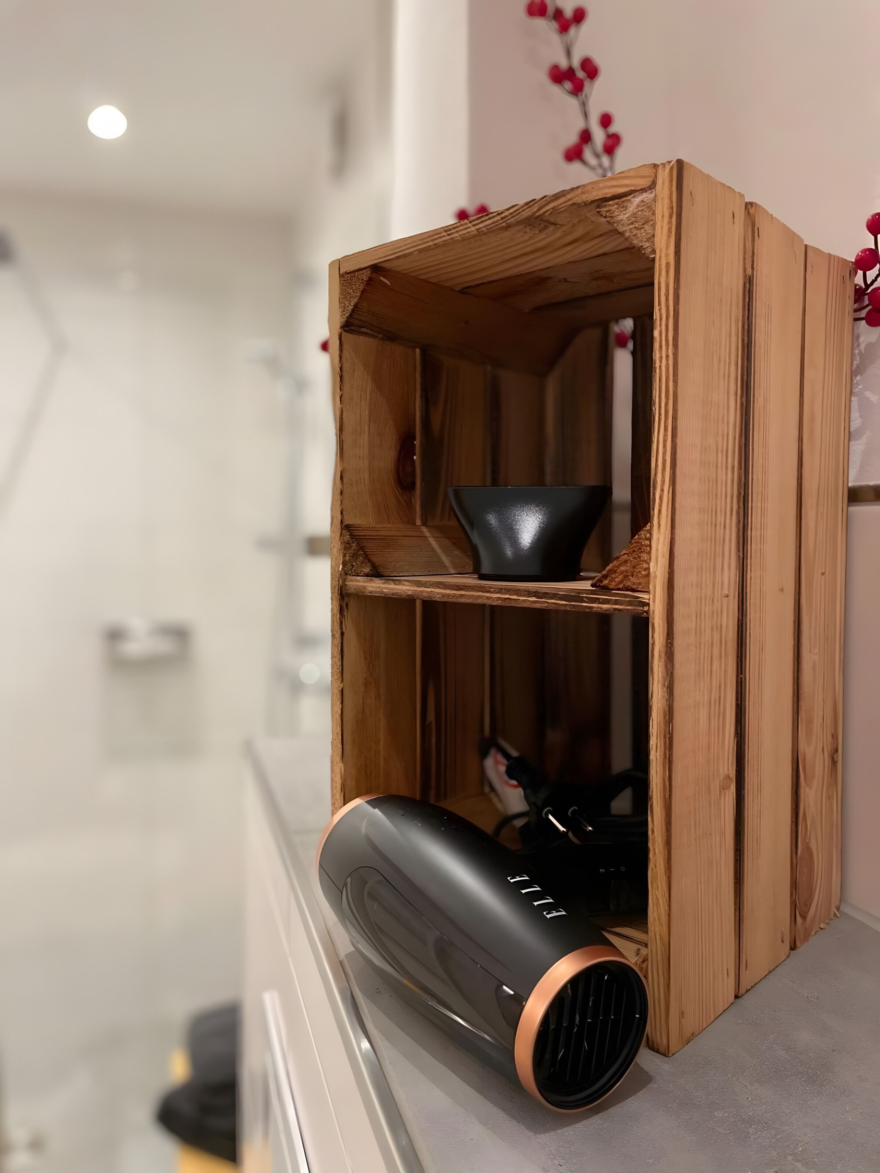 A wooden shelf with a black object and a black bowl.