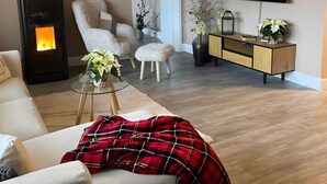 Una sala de estar con chimenea, un sofá, un televisor y un mueble de madera.