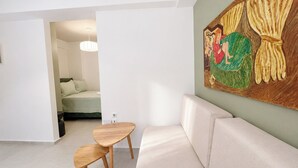 Una sala moderna con un sofá, una mesa de madera y un cuadro en la pared.
