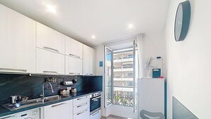Een moderne keuken met witte kasten, een zwart aanrecht en een ingebouwde oven.