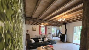 A living room with a sofa, a dining area with a table and chairs, and a kitchen area with a refrigerator. - Idyllic home, pets and parking - 6 guests (Saint-Vincent-Jalmoutiers)