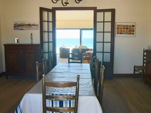 Ein Esszimmer mit Meerblick, einem Holzschrank und einem gerahmten Bild an der Wand.