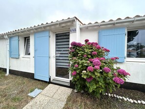 A building with a number 698, blue shutters, and a hydrangea bush in front. - Quiet house, heated pool - 5 guests (Bretignolles-sur-Mer)