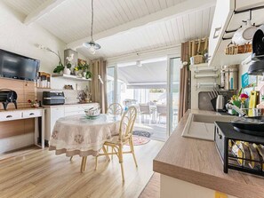 Eine moderne Küche mit Essbereich, Holzboden und einem Fernseher.
