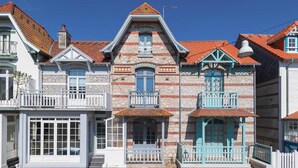 Eine Reihe von traditionellen Gebäuden im europäischen Stil mit Steinverkleidungen, mehreren Balkonen und roten Ziegeldächern.