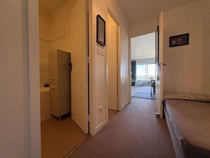 Ein Hotelzimmer mit Bett, einer Tür zum Balkon und Blick ins Freie.
