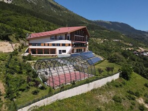 A two-story building with a red roof, solar panels, and a roller coaster. - AbiGreen  (Prevallë)