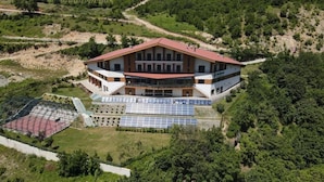 Ein großes Gebäude mit rotem Dach, zahlreichen Fenstern und Solaranlagen.
