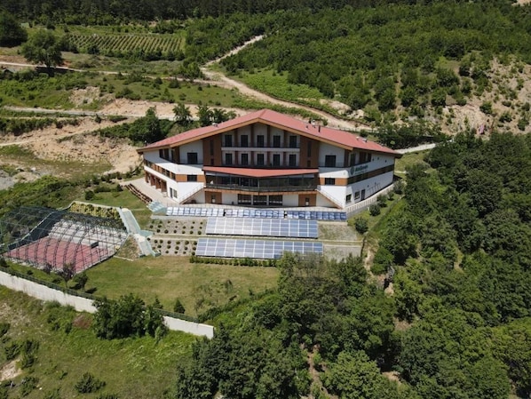 A large building with a red roof, multiple windows, and solar panels.