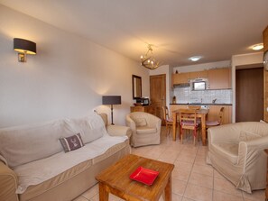 Ein Wohnzimmer mit Sofa, Sesseln, Couchtisch, Lampe und einer Chandelier.