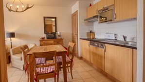 Una cucina compatta con zona pranzo, forno a microonde, tostapane e lavello.