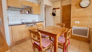 Una cucina con mobili in legno, un fornello e un tavolo da pranzo con sedie a quadri.