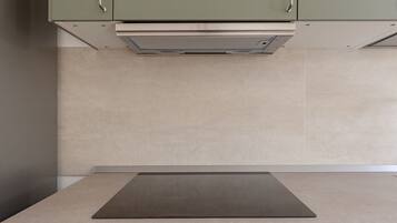 A kitchen with a countertop, cabinets, and a range hood.
