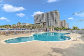 A hotel with a large pool, sun loungers, and a high-rise building in the background. - North Hampton 901 Oceanfront in/out pool/Beach (Myrtle Beach)