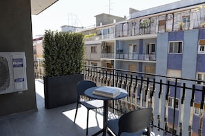 A balcony with a table and chairs, a potted plant, and a Haier air conditioning unit. - Mas Collection - Bari Monfalcone (Bari)