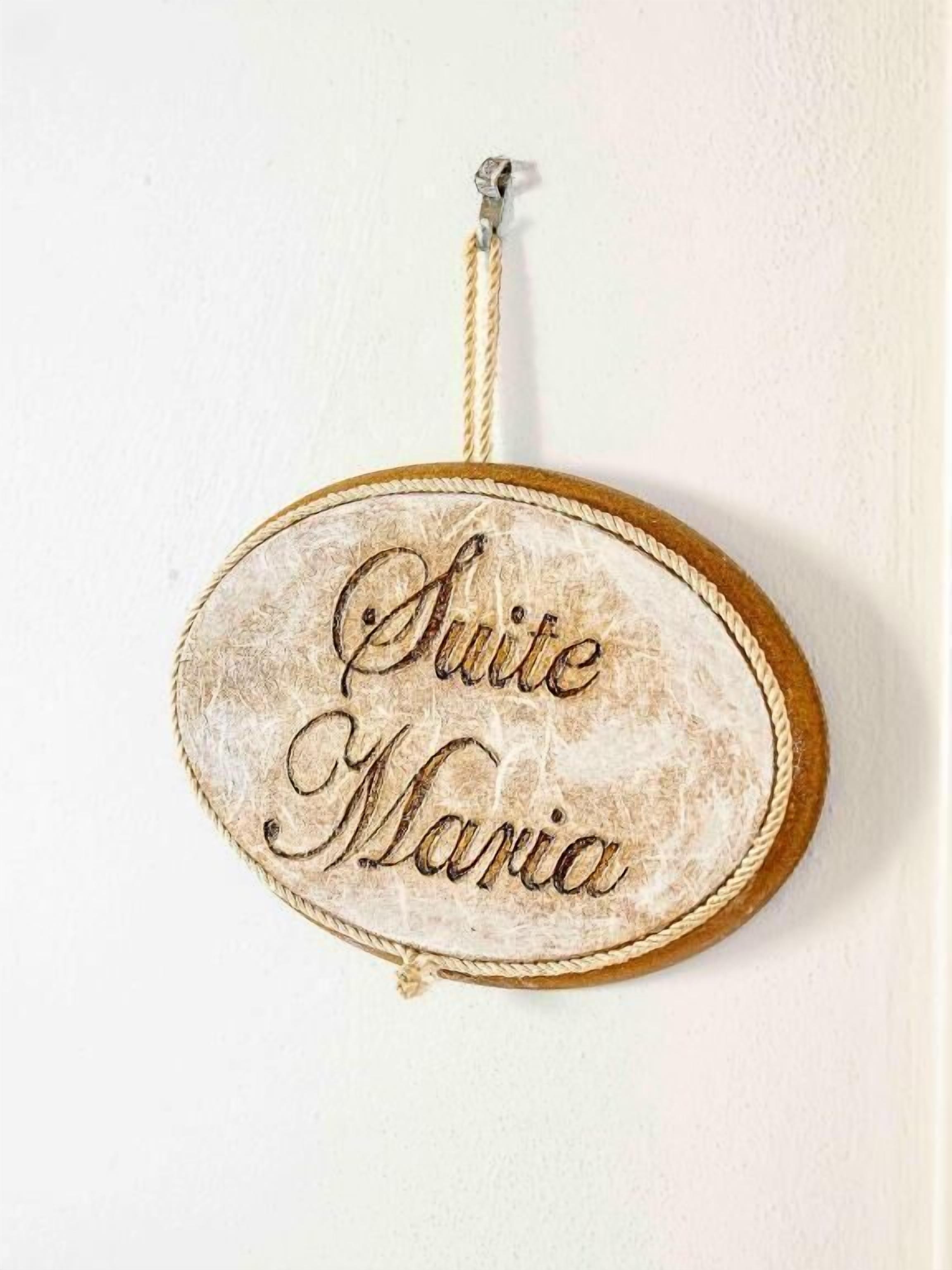 Un letrero con el texto 'Suite Maria' en una pared.