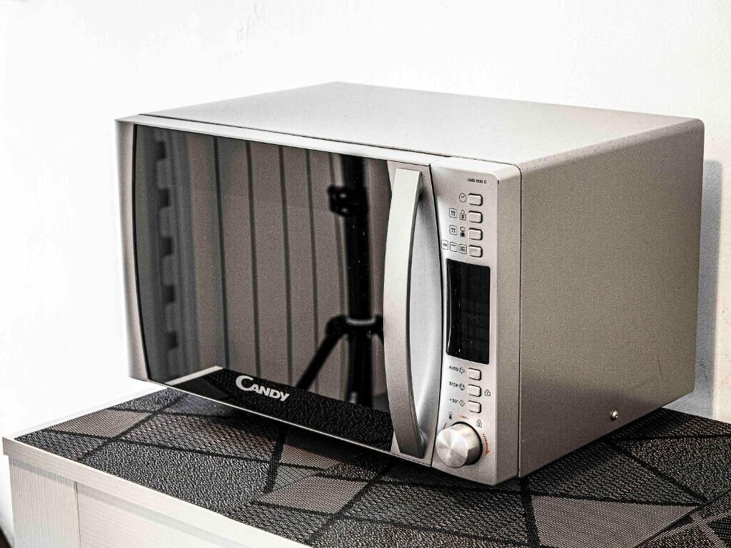 Un horno microondas con panel de control y cable de alimentación.