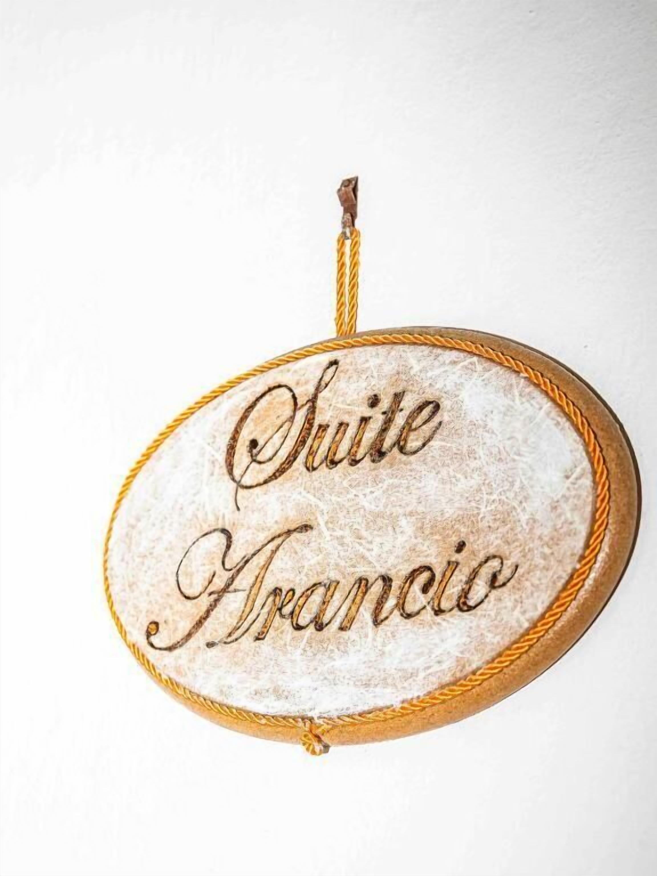 A sign with the text 'Suite Francio' on a textured surface.
