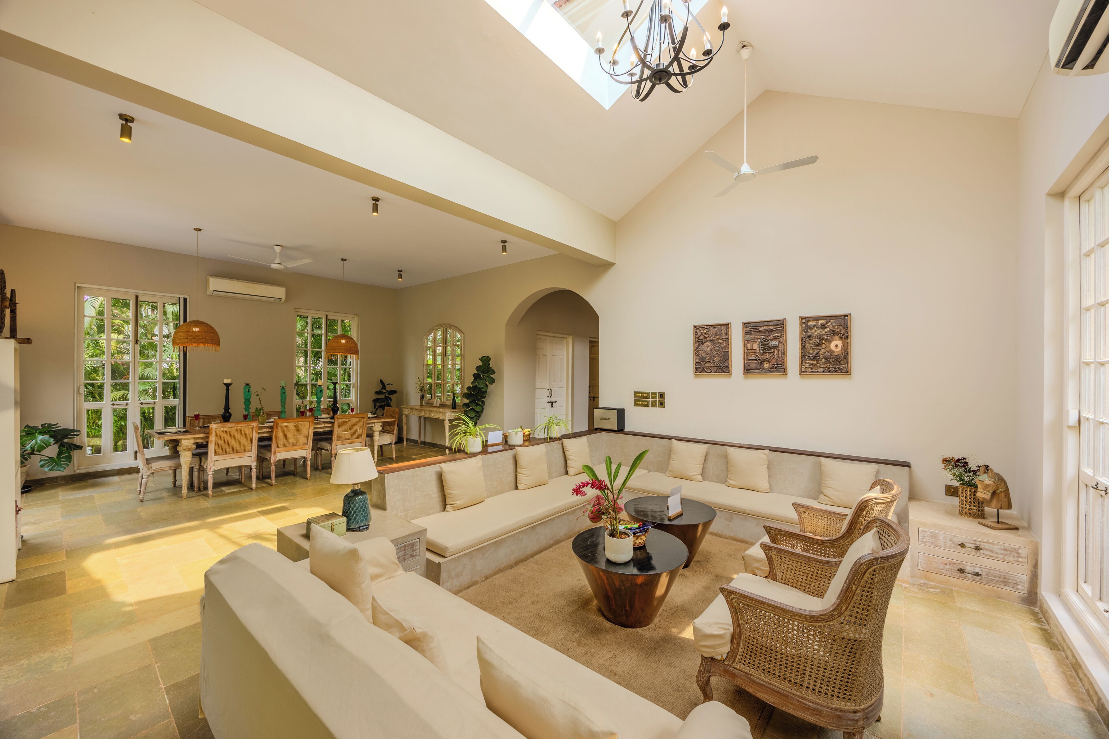 A spacious living area with a high ceiling, a dining area, and a seating area with a coffee table.