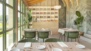 A restaurant with a wine wall, wooden ceiling, and large windows. - Tenuta Asmara Luxury Resort: Garden View Suite (Toscana)