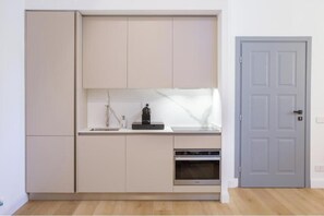A compact kitchen with cabinets, a countertop, a coffee maker, and an oven. - Tenuta Asmara Luxury Resort: Deluxe King Suite (Toscana)