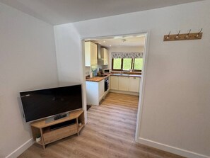 Eine moderne Küche mit weißen Schränken, einer Holz Arbeitsplatte und einer eingebauten Mikrowelle.
