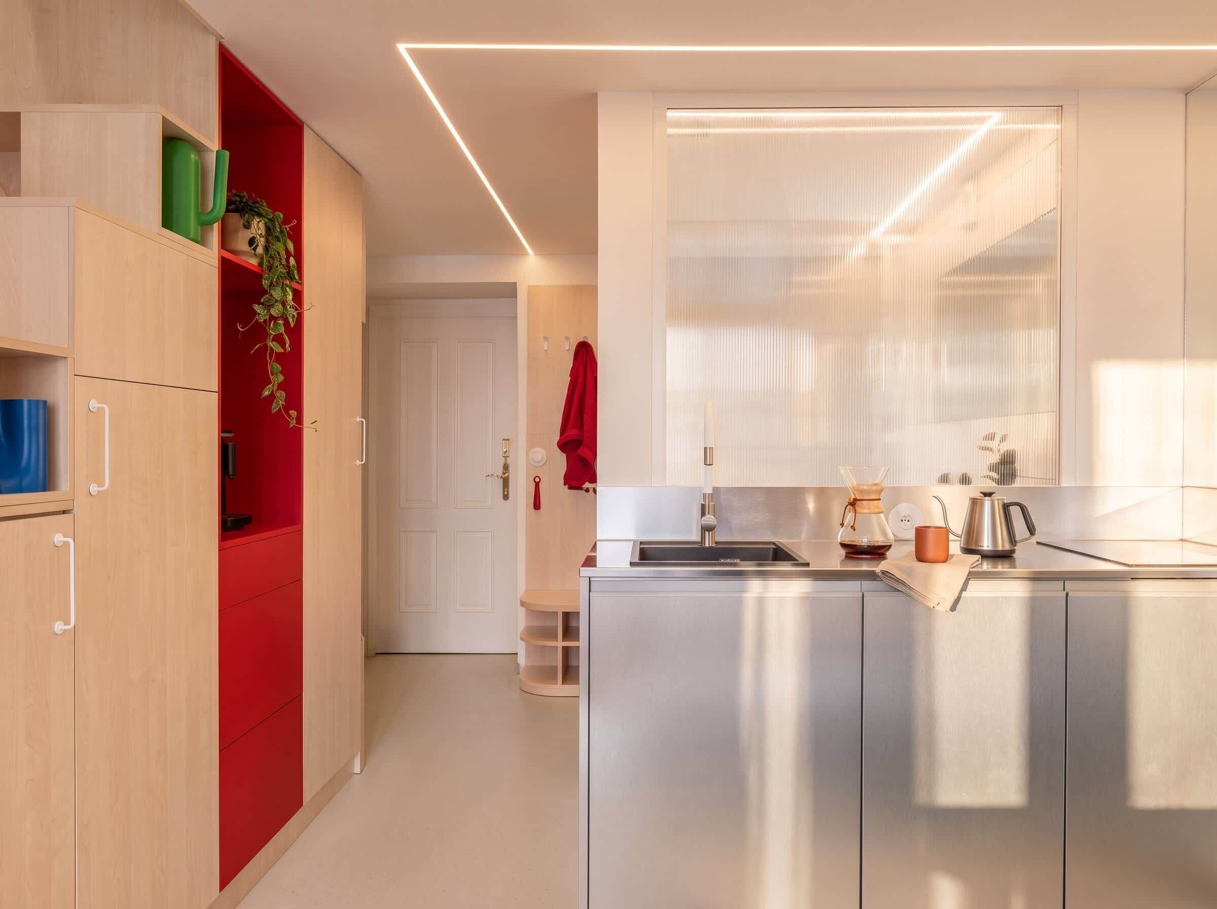 A modern kitchen with a built-in oven, a coffee maker, and a sink.