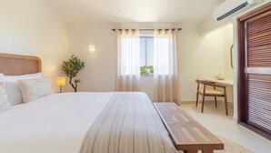 A hotel room with a bed, a small table, a chair, a lamp, and a window with curtains. - S o Rafael Apartment by Minhos Guest (Albufeira)