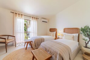 A hotel room with two beds, a chair, a small table, and a potted plant. - S o Rafael Apartment by Minhos Guest (Albufeira)