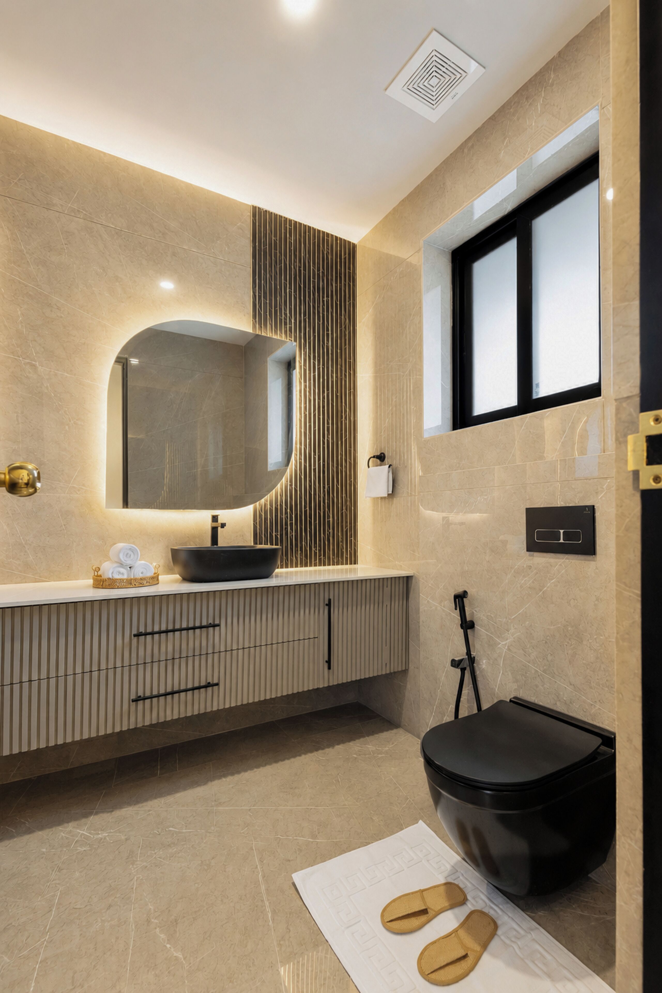 Ein modernes Badezimmer mit einem großen Spiegel, einem schwarzen Waschbecken, einer Toilette und einem Fenster.