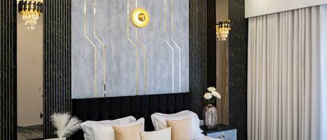 A modern bedroom with a large bed, a chandelier, and a marble-patterned floor.