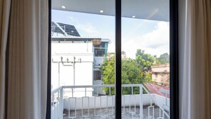 A balcony with a white railing, a view of buildings, and a clear sky. - ELIVAAS Nedumbally 4 BHK Villa (Ernakulam)