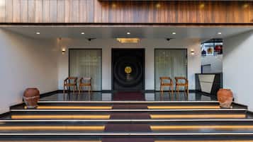 A staircase leading to a room with a large circular window and a wooden ceiling.